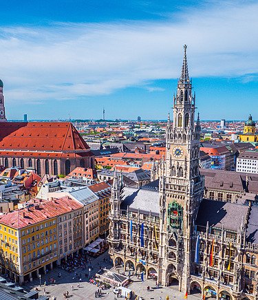 Foto mit Blick auf die Marienkirche in München mit dem Panorama der Stadt und den Alpen im Hintergrund