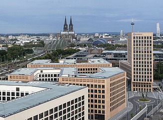 Panorama mit Hochaus aus hellem Stein mit dunklen Fensterrahmen