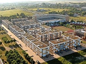 Mehrere Wohnblocks in einer parkänlichen Landschaft