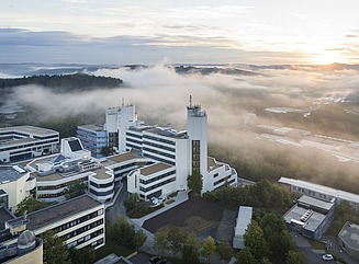 Fugleperspektiv af universitetscampus med forskellige hvide bygninger med vandrette vinduesdesigns