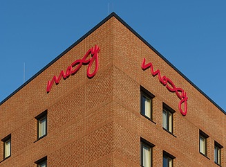 Hjørnebygning i mursten med bogstaverne Moxy
