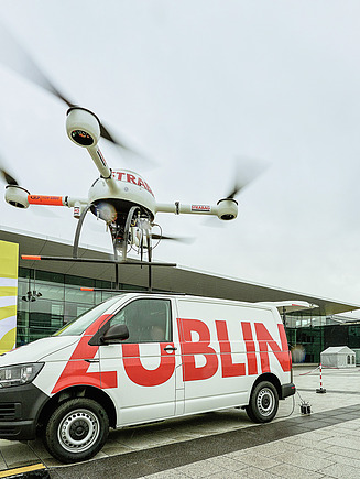 Drohne schwebend vor Züblin Transporter auf Messeplatz