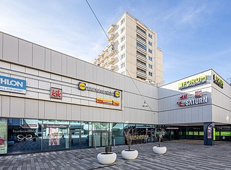 Zwei Rolltreppen in einem Einkaufszentrum, zwischen den Rolltreppen silberne Kugeln