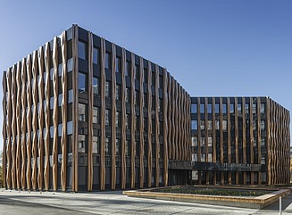 Bürogebäude mit vertikalen strukturierten FassadenelementenSaturn über dem Eingang
