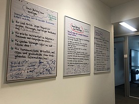 three framed agreements on cooperation written in felt-tip pen on the wall of an office corridor