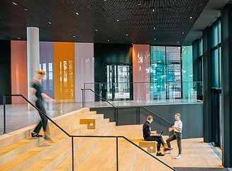 L-förmiges Bürogebäude mit horizontal durch weiße Fensterelemente strukturierte Fassade