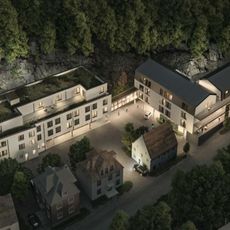 Natbillede af et L-formet bygningskompleks i skoven
