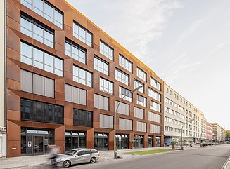 Geschwungene begrünte Fassade eines Verkaufsgebäudes, Schriftzug Saturn über dem Eingang