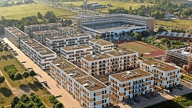 Mehrere Wohnblocks in einer parkänlichen Landschaft