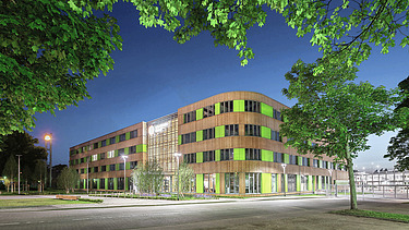 Nachhaltiges Bauen Gebäude bei Dämmerung mit Holzfassade und grünen Elementen