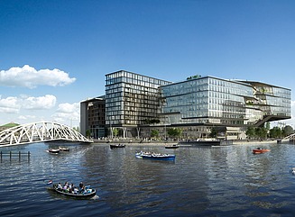 Blok med tre bygninger med glasfacader på havnefronten, med tre både på toppen
