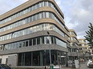 Hjørnebygning med afrundet glasfacade