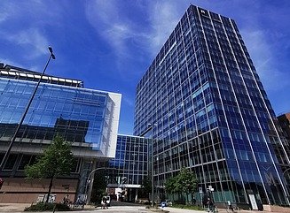 T-formede glasfacader på en kontorbygning med en vej, der løber under den 