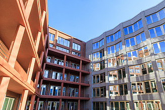 Here you can see a photo of an office building, an attractive red brick façade and blue sky