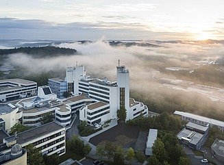 Vogelperpektive auf Universitätscampus mit verschiedenen weißen Gebäuden mit horizontalen Fenstergestaltungen