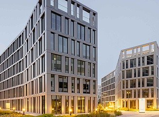 Office complex with curved façades with large window fronts and green spaces in between