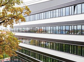 L-formet kontorbygning med en facade, der er struktureret horisontalt af hvide vindueselementer