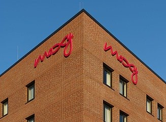 Hjørnebygning i mursten med bogstaverne Moxy