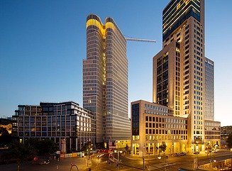 I forgrunden Mindeskirken i Berlin, bag den to lyse, sammenhængende højhuse med afrundede facader