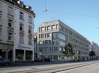 Straße mit grauem Eckgebäude