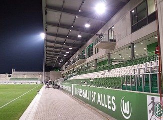 Curved green façade of a sales building, Saturn lettering above the entrance