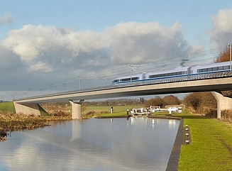 Betonbrücke mit Hochgeschwindigkeitszug über einen Kanal mit Grünflächen an den Ufern