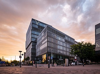 Zwei Gebäude mit vertikal strukturierter Glasfassade