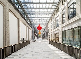 Rolltreppe in einem Einkaufscenter, strukturierte Decke mit Leuchtstoffröhren, geradeaus Rewe, rechts DM