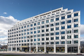 11-etagers hvid bygning med butikslokaler i stueetagen og The Student Hotel-bogstaver